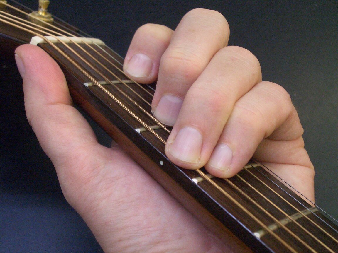 Beginner guitar student learning chords.